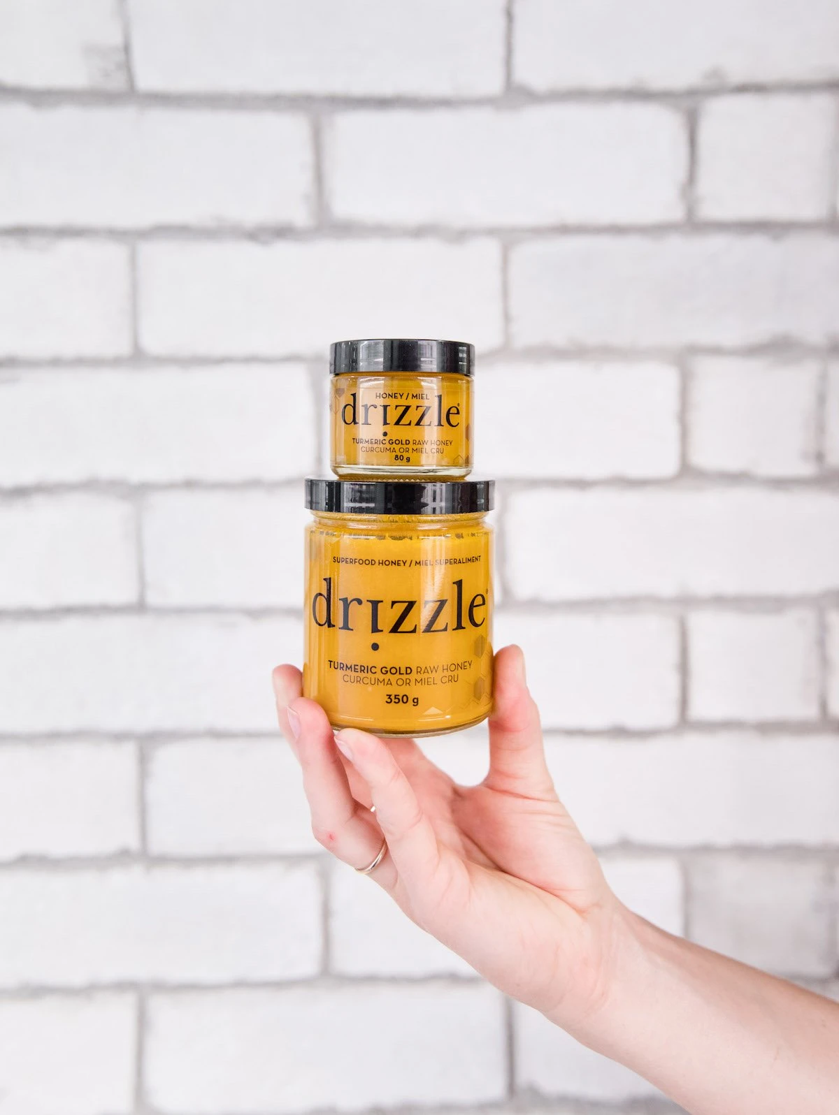 Turmeric Gold honey mini jar stacked on Turmeric Gold big jar of honey