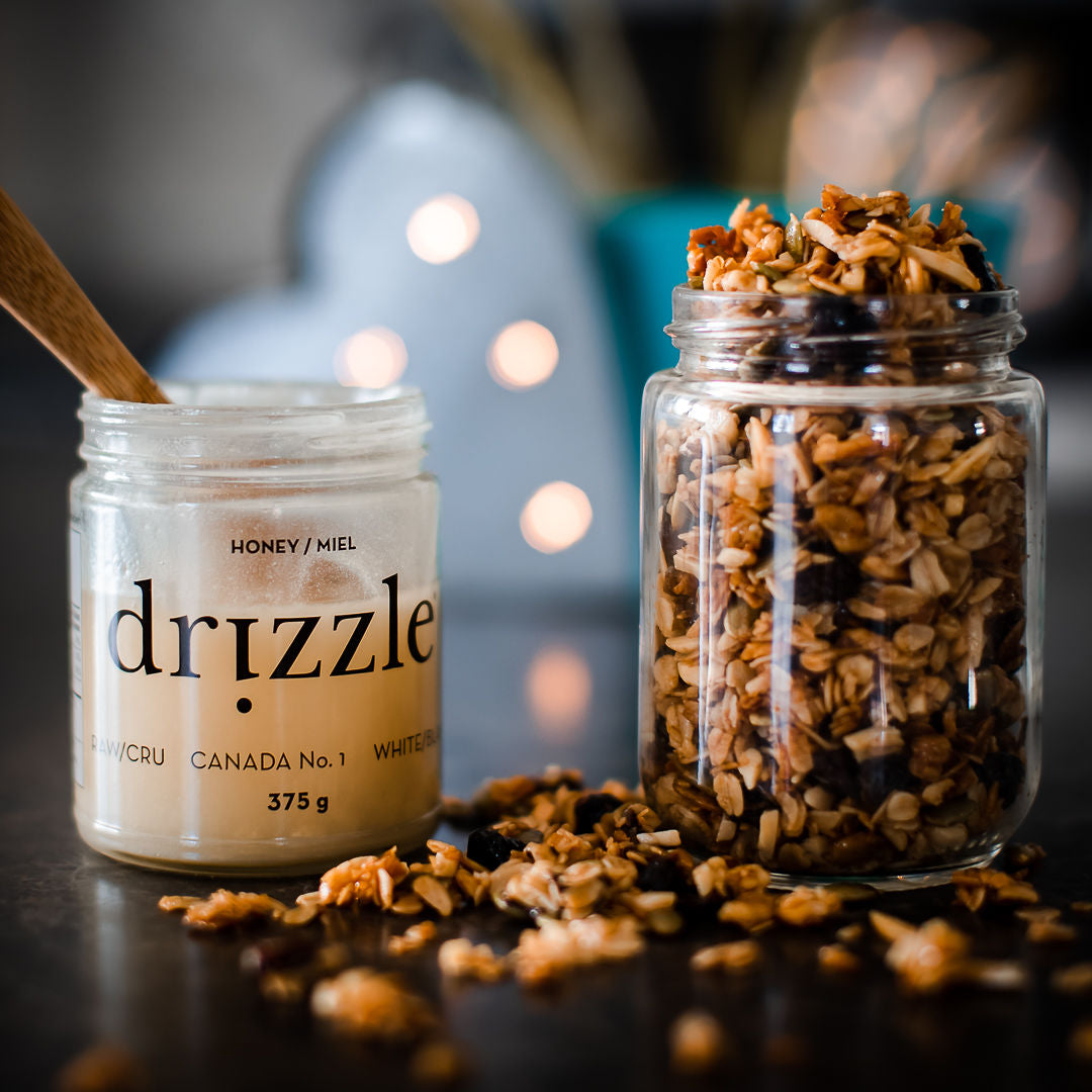 jar of open honey beside a jar of granola