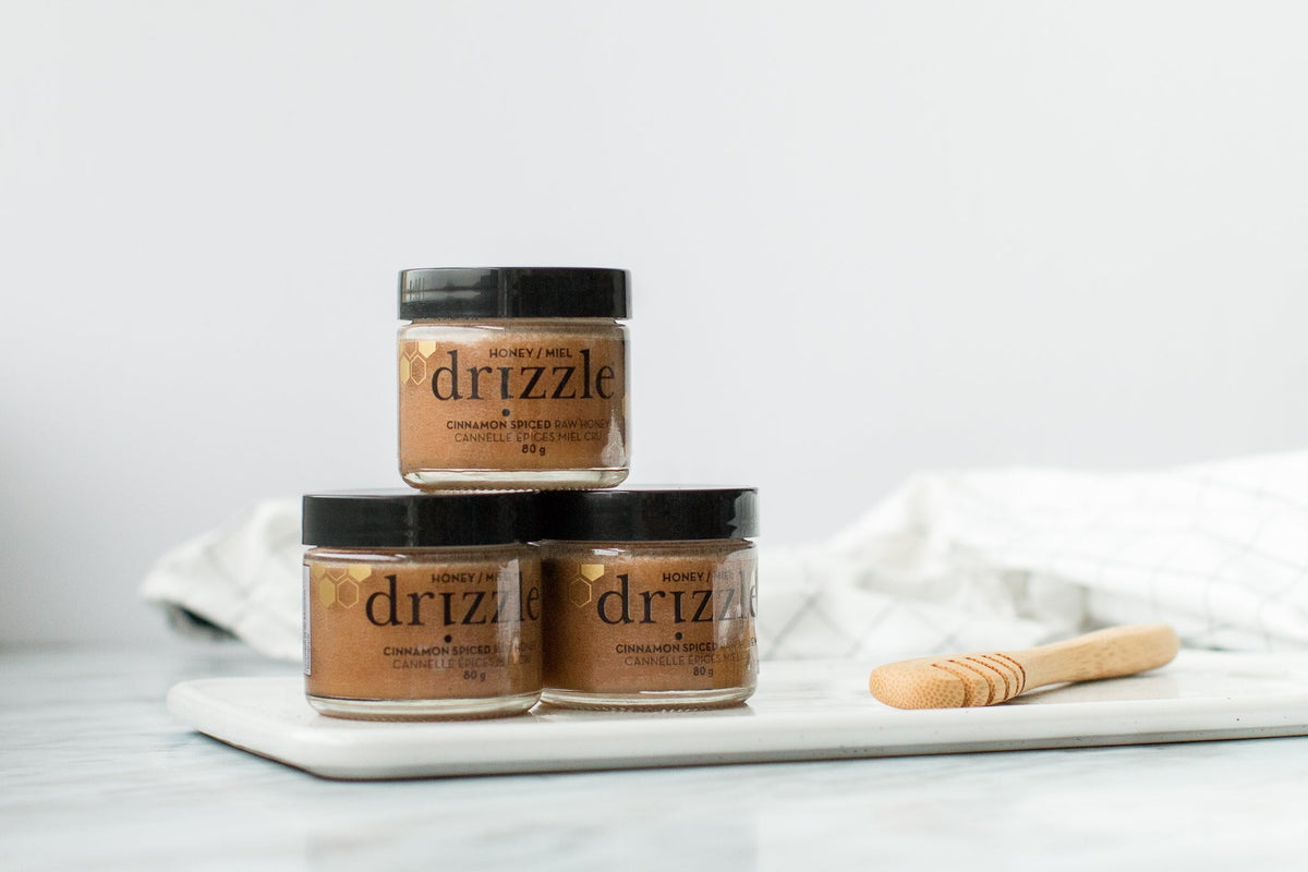 A stack of jars of Mini Drizzle Cinnamon Spiced Raw Honey.