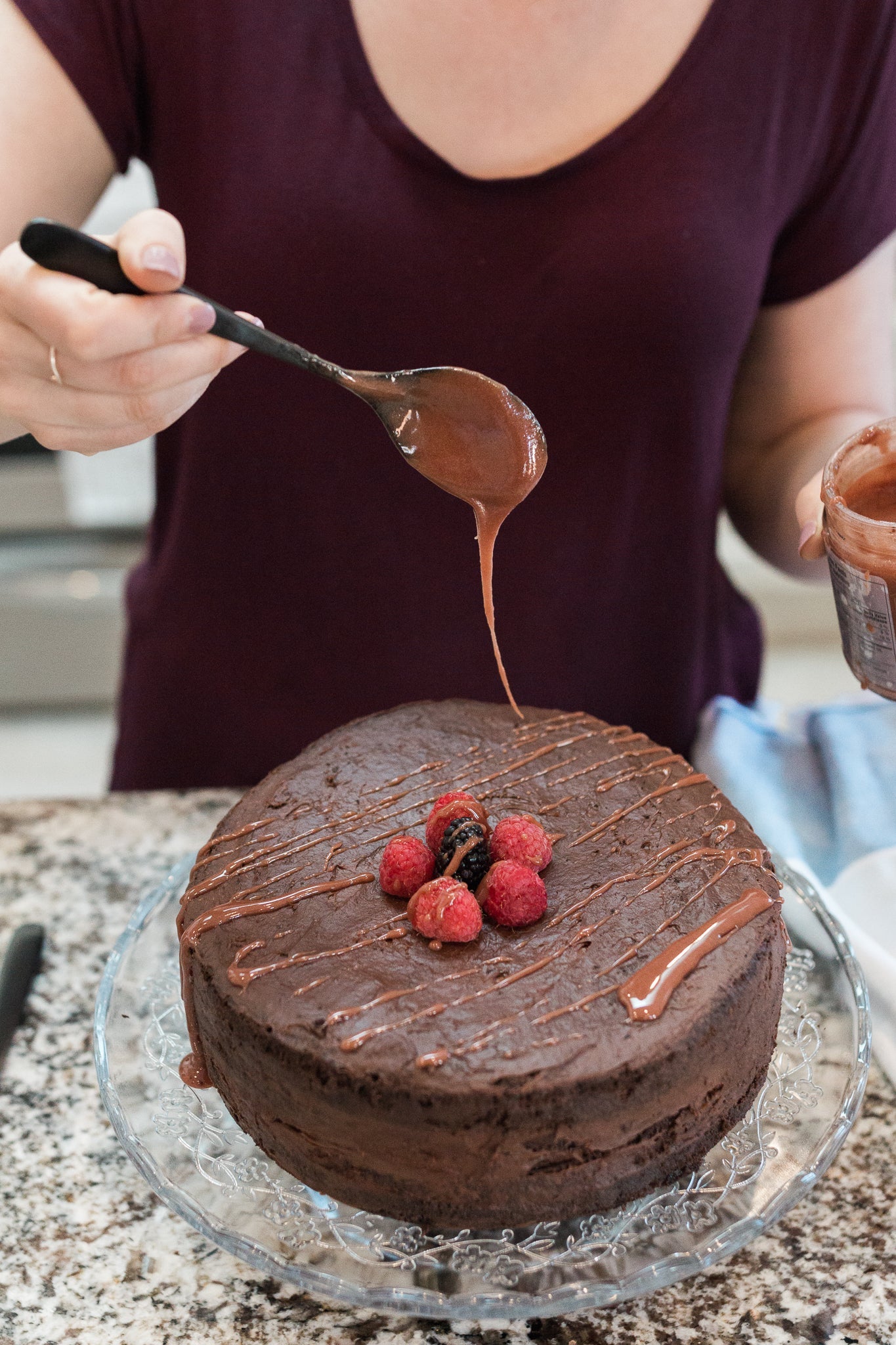 Photo of Drizzle Cacao Luxe Honey being used to glaze a round chocolate cake.