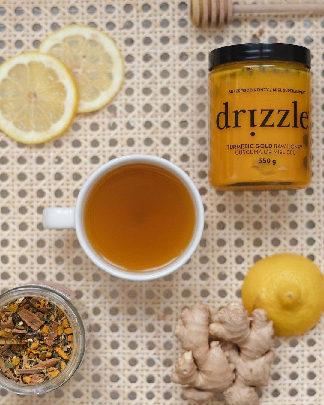 Top down view of a mug of tea with honey beside it