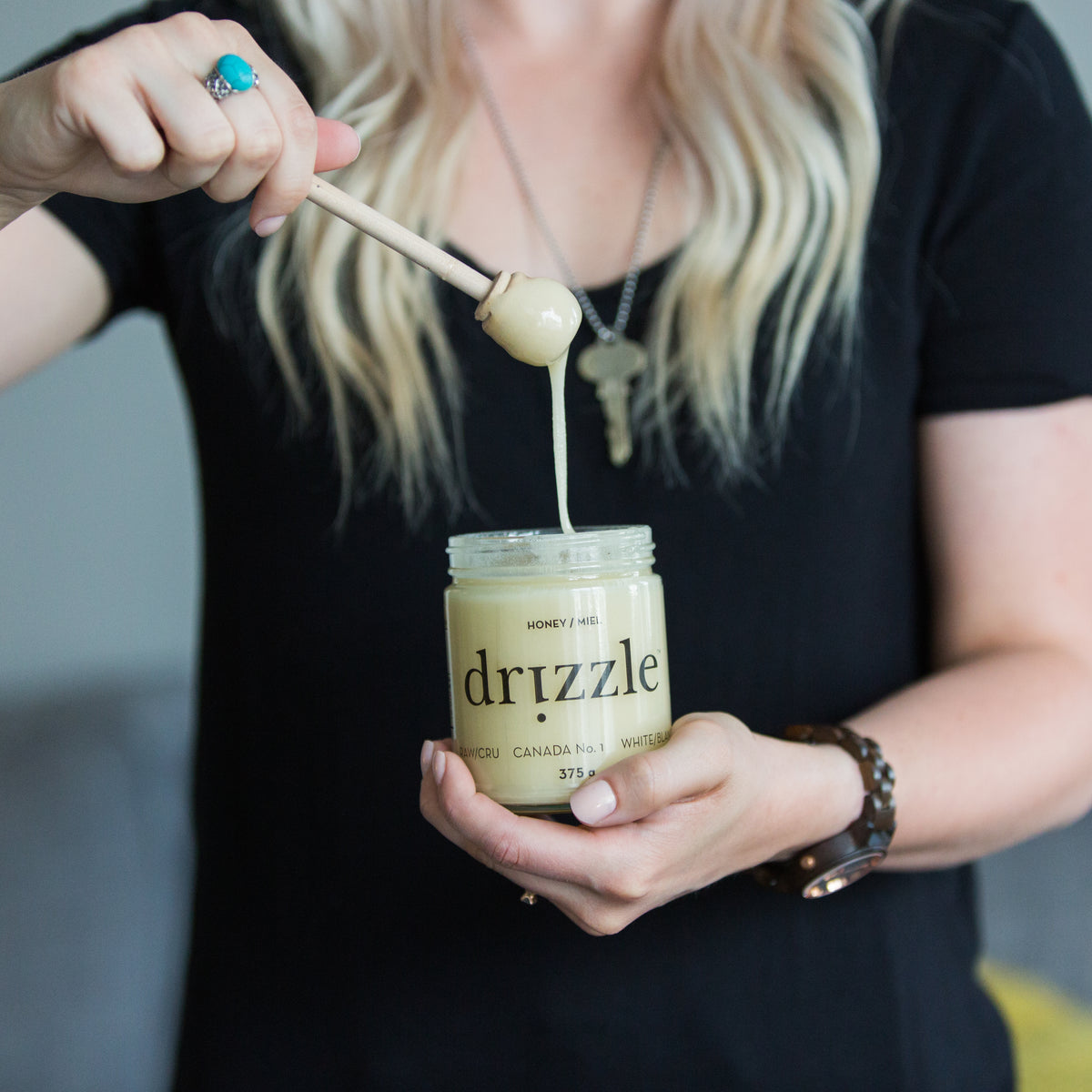 women holding a jar of white raw honey