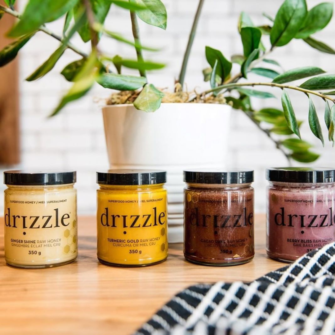 four honey jars sitting on a cutting board