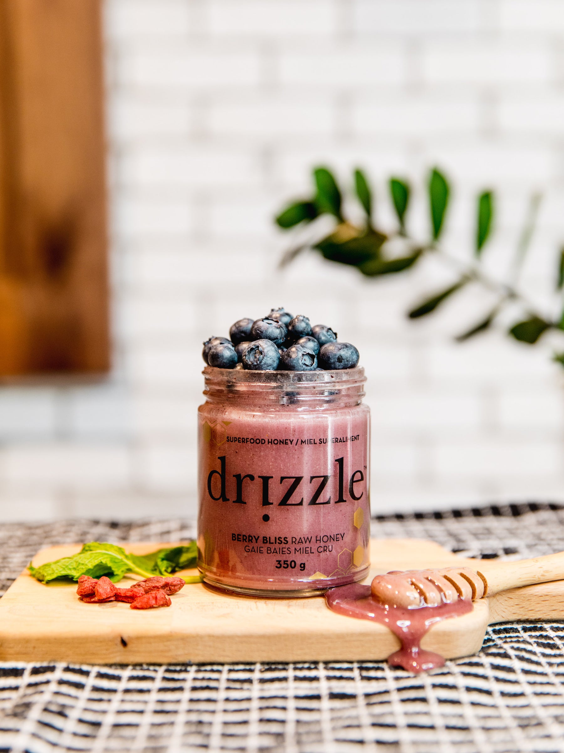 Photo of Drizzle Honey Berry Bliss sitting atop a cutting board with blueberries and drizzle.