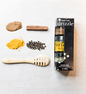 Drizzle Taster Trio Box next to a drizzle spoon and raw ingredients.