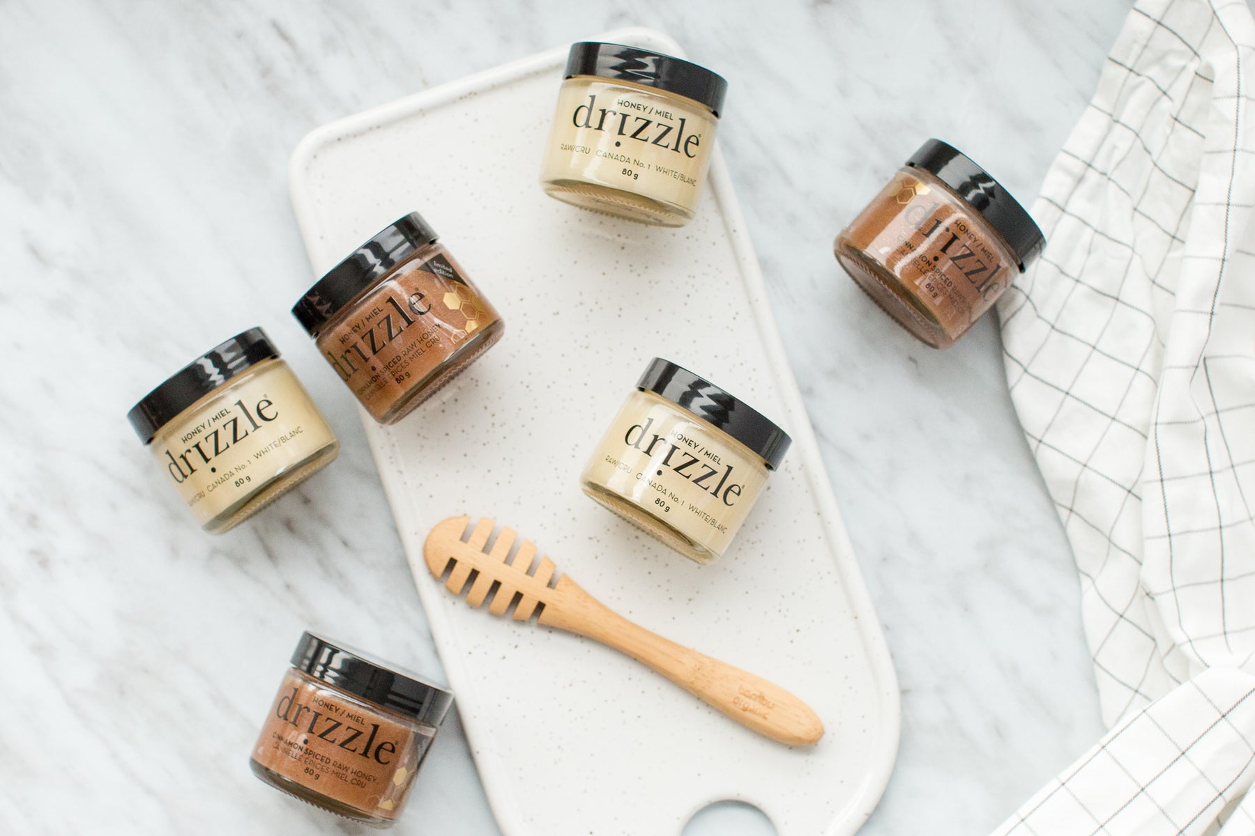 mini jars of raw honey on a cutting board