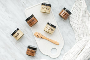 Mini drizzle honey jars on a cutting board