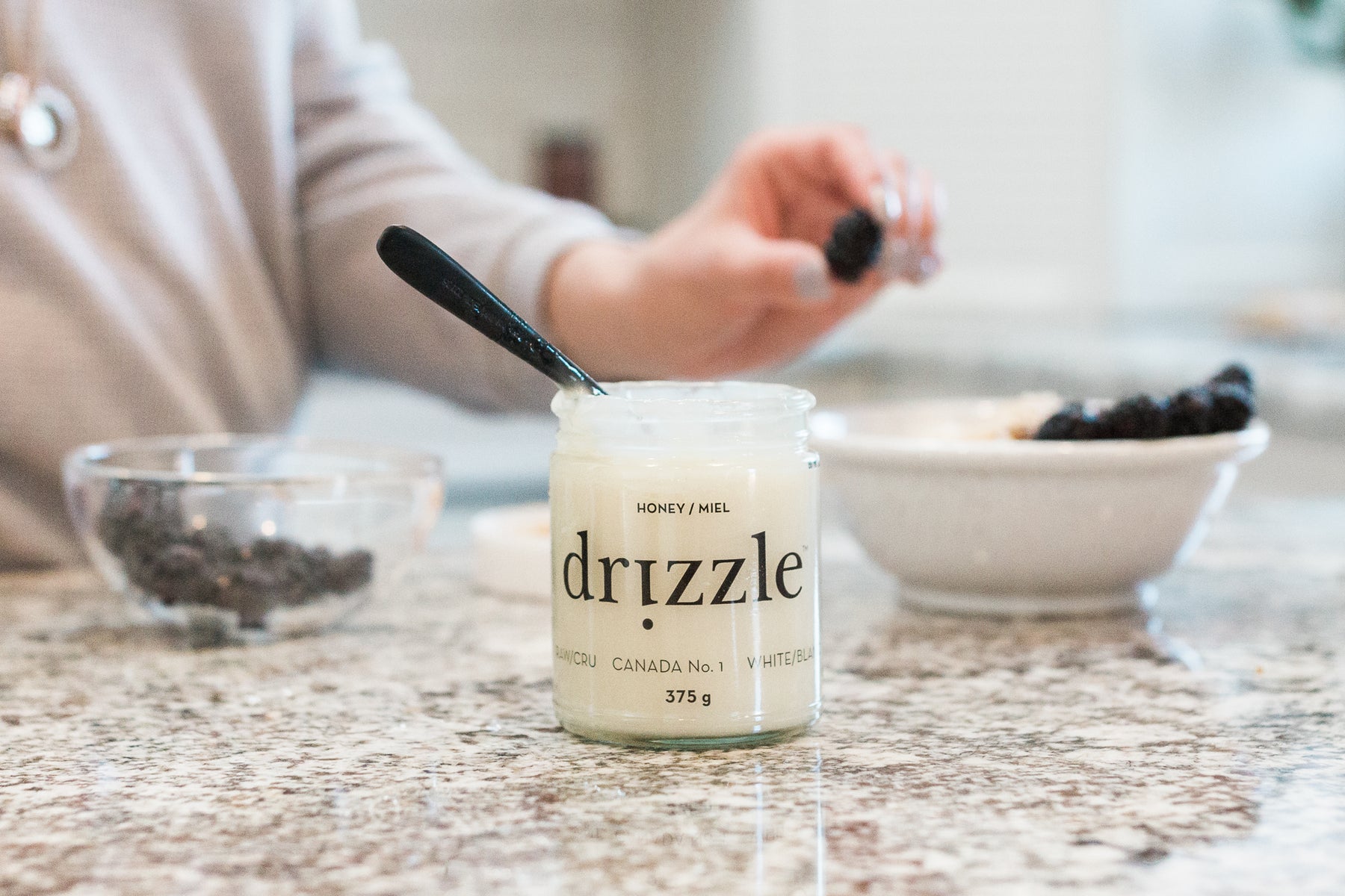 a spoon in a white honey jar