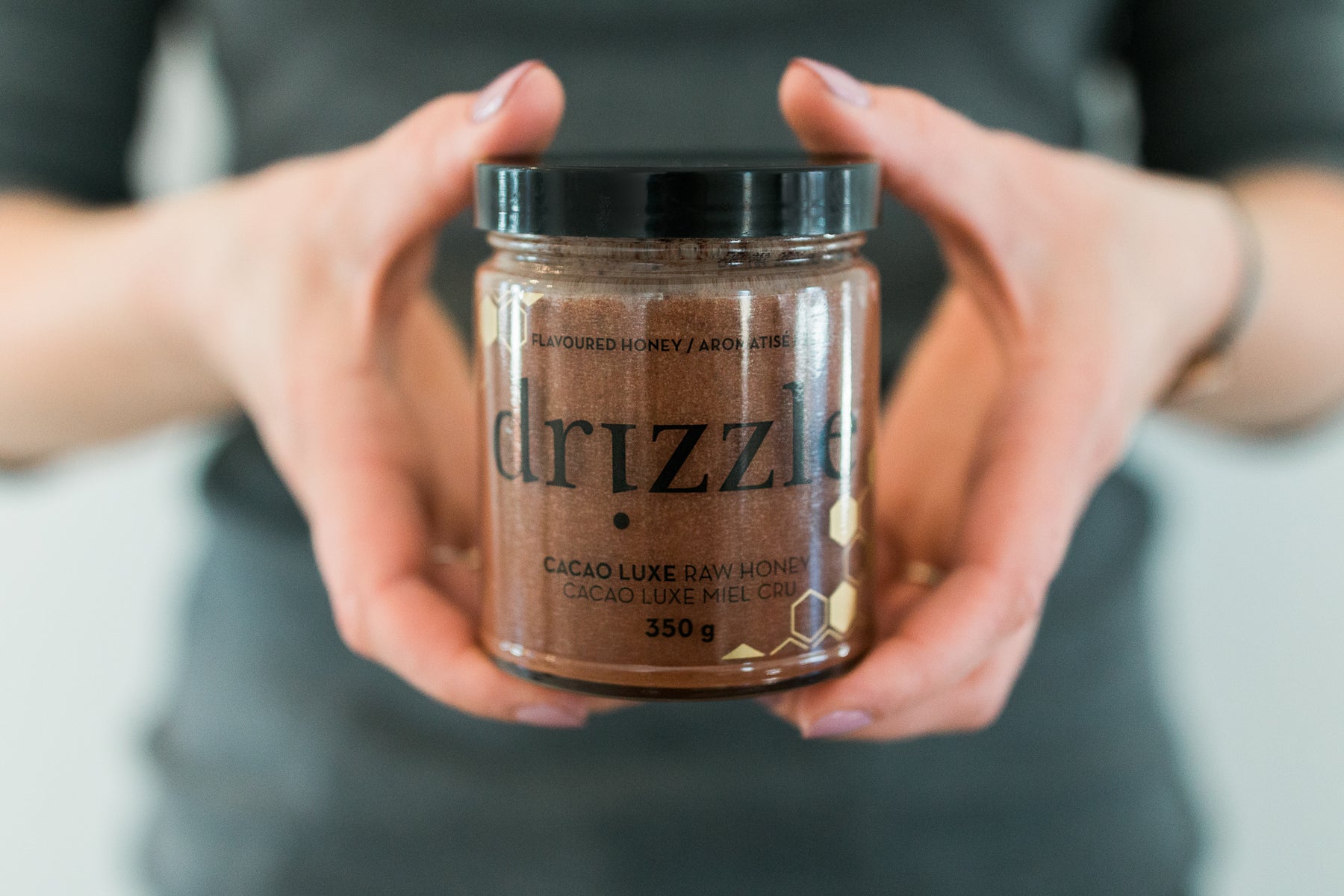 Photo of Drizzle Cacao Luxe Honey being held by a woman.