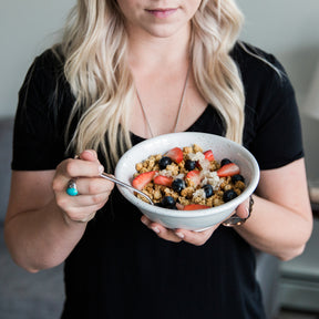 A woman holding a smoothie bowl.